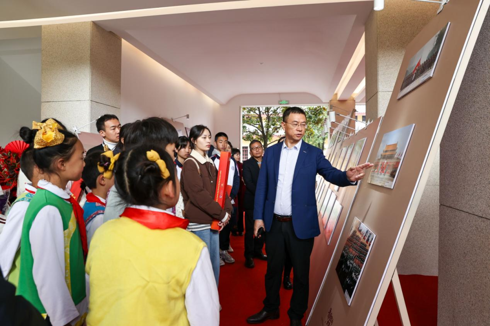 12月8日,新华社中国图片社副总裁王湘宏为参观展览的师生讲解图片。新华社记者 江文耀 摄